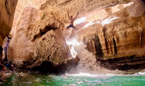 Junge springt ins Wasser im Wadi Shab im Oman – Oman mit Kindern