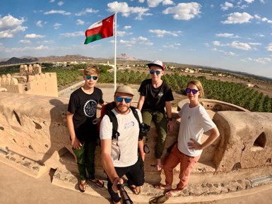 Familie fotografiert sich vor dem historischen Jabrin Fort mit seinen kunstvollen Fassaden – Oman Reise mit Kindern