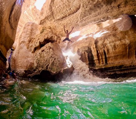 Junge springt ins Wasser im Wadi Shab im Oman – Oman mit Kindern