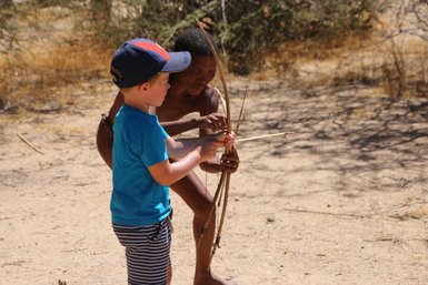 Ein Kind versucht einen Bogen zu spannen - Namibia Urlaub mit Kindern