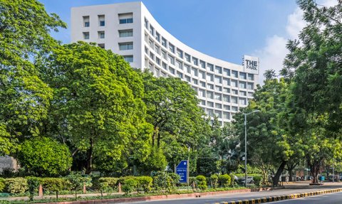 Das moderne Hotel 'The Park' erhebt sich elegant zwischen üppigem Grün und strahlend blauem Himmel in Neu-Delhi.