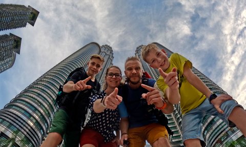 Familie hält einen Moment vor den Petronas Towers in Kuala Lumpur fest – Malaysia & Borneo Familienreise