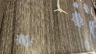 Ein beeindruckender Wasserfall im Dubai Mall, mit silbernen Skulpturen von Tauchern, die elegant in die Tiefe springen.