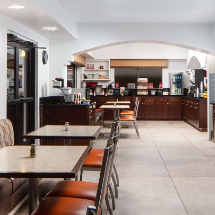 Ein helles Frühstücksrestaurant mit modernen Tischen und Stühlen, bereit für Gäste, die eine Mahlzeit genießen möchten.