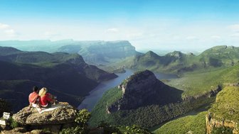 Ein Paar sitzt auf einem Felsen und blickt auf die Landschaft des Blyde River Canyons – Südafrika Familienreise