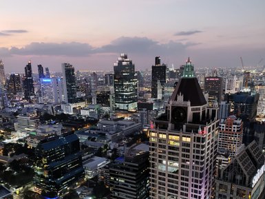 Beleuchtete Straßen und Gebäude im Herzen von Bangkok bei Nacht – Thailand mit Kindern
