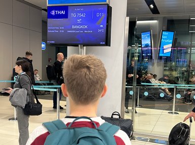 Teenager wartet am Gate auf seinen Abflug nach Bangkok – Thailand Reise mit Kindern