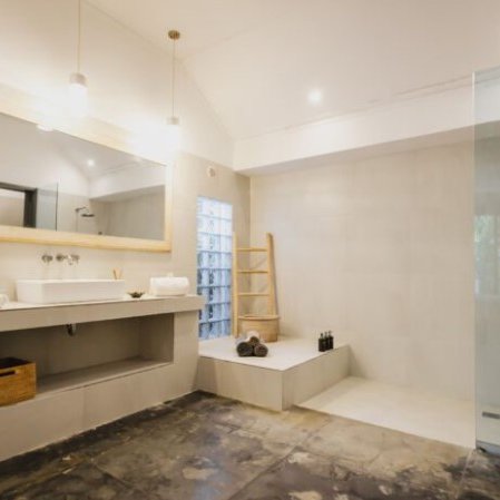 Ein modernes Badezimmer mit einem großen Spiegel, einer eleganten Dusche und einem Holzregal für Handtücher und Pflegeprodukte.