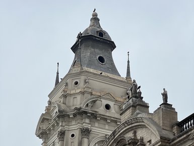 Die beeindruckende Fassade der Basilika San Francisco in Lima zeigt kunstvolle Details und Statuen auf dem Dach.