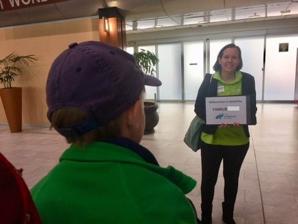 Freundlicher Reiseleiter empfängt Familien am Flughafen mit einem gut sichtbaren Schild – Südafrika mit Kindern