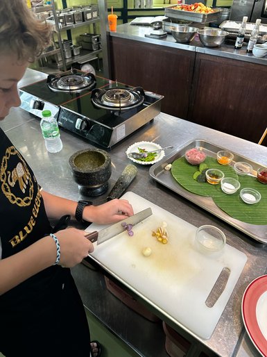 Kind bereitet Gemüse beim thailändischen Kochkurs zu – Thailand Familienreise