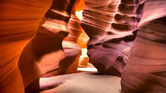 Die schmalen Wände des Antelope Canyon zeigen beeindruckende rot-orange Farbtöne, die durch das Licht wunderschön hervorgehoben werden.