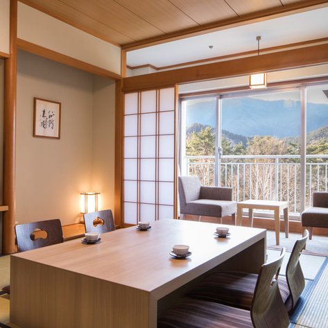 Ein stilvolles Hotelzimmer mit einem großen Fenster, das einen Blick auf die Berge und die Natur bietet.