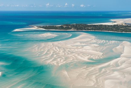 Eine Drohnenaufnahme von weißen Sandstränden und dem blauen Meer von oben