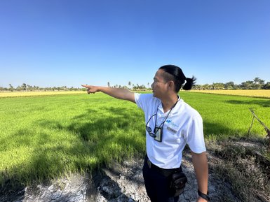 Einheimischer und Reiseleiter Thana zeigt auf Reisefeld - Thailand Familienreise