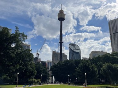 Der Sydney Tower ragt hoch über die Stadt, umgeben von modernen Gebäuden und intensiv grünem Parkland.