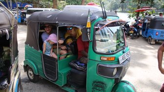 Familie sitzt gemeinsam in einem grünen Tuk-Tuk in Kandy – Sri Lanka Familienreise