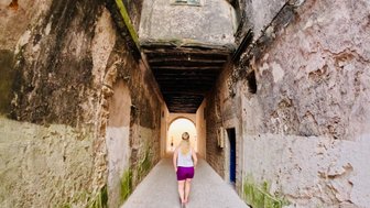 Frau spaziert durch eine enge Gasse in Essaouira – Marokko Reise mit Kindern