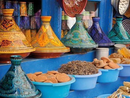 Lebendiger marokkanischer Souk mit einer Vielfalt an bunten Tajines und Gewürzen – Marokko Familienreise