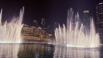 Die beeindruckenden Wasserfontänen tanzen im Rhythmus der Musik, während die Lichter der Stadt im Hintergrund funkeln.