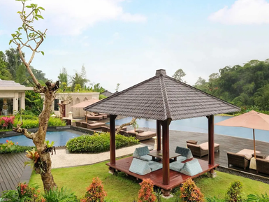 Ein stilvoller Pavillon mit bequemen Sitzgelegenheiten steht in einem üppigen Garten neben einem glitzernden Pool.