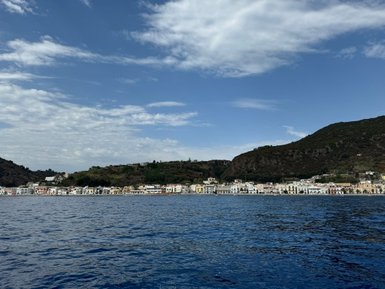 Eine malerische Küstenlinie mit bunten Häusern, die sich entlang des Wassers erstrecken, unter einem klaren blauen Himmel.