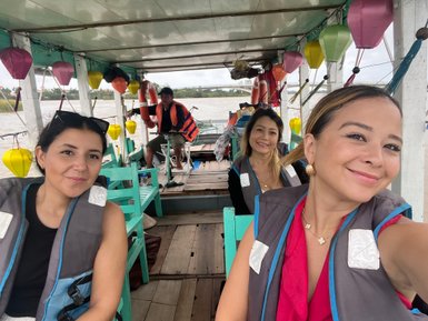 Frauen fahren in einem traditionellen Boot auf dem Fluss – Vietnam mit Kindern