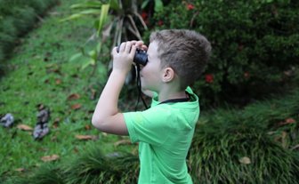 Junge beobachtet die Tierwelt mit Fernglas bei der Maquenque Eco Lodge im Sarapiquí-Tal – Costa Rica Reise mit Kindern