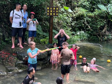 Fröhliche Kinder plantschen und spielen im klaren Wasser des Li-Flusses bei Yangshuo – China mit Kindern
