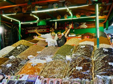 Zwei Kinder entdecken bunte Gewürze an einem traditionellen Marktstand in Marrakesch – Marokko Familienreise