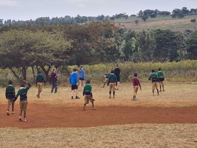 Reisende Kinder spielen gemeinsam mit einheimischen Schulkindern – Tansania Familienreise