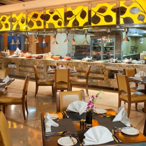 Ein elegantes Restaurant mit Holztischen und Stühlen, dekoriert mit frischen Blumen und stilvollen Servietten auf den Tischen.
