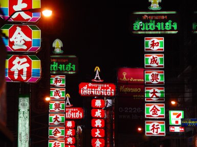 Reklametafeln und Schriftzeichen erhellen die Nacht – Thailand Reise mit Kindern