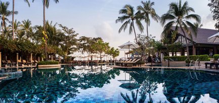 Ein luxuriöser Pool umgeben von Palmen und Liegen, reflektiert die ruhige Atmosphäre des Hotel Peace Resort in Koh Samui.