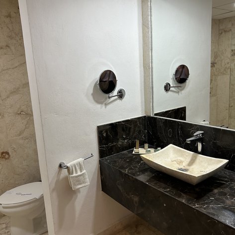 Ein modernes Badezimmer mit einer eleganten schwarzen Marmorwaschtisch und einer stilvollen Schüssel aus hellem Material.