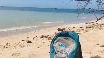 FFR Rucksack liegt im Schatten am weißen Sandstrand von Cahuita – Costa Rica Familienreise