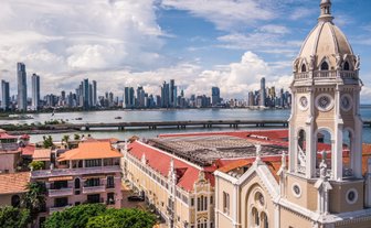 Der Blick auf das moderne Stadtbild von Panama City zeigt hohe Wolkenkratzer und das ruhige Wasser des Hafens im Vordergrund.