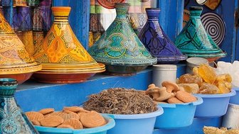 Lebendiger marokkanischer Souk mit einer Vielfalt an bunten Tajines und Gewürzen – Marokko Familienreise