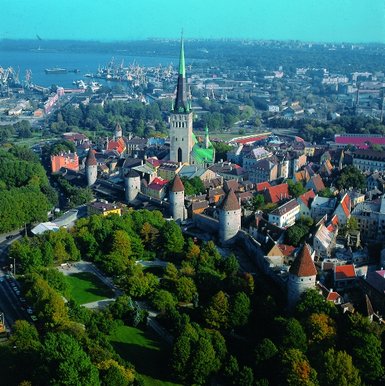 Ein Blick auf die Altstadt von Tallinn mit ihren historischen Türmen und dem grünen Kirchturm im Hintergrund.
