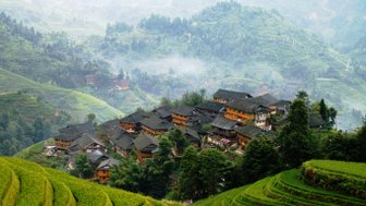 Panorama der Reisterrassen von Longsheng mit Blick auf traditionelle Holzhäuser – China Familienreise