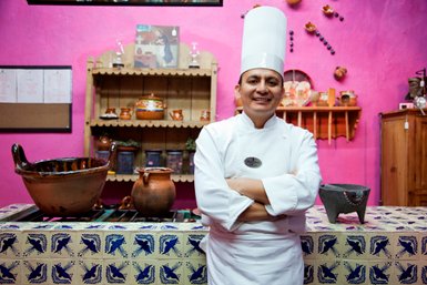 Koch in einer traditionell eingerichteten mexikanischen Küche – Mexiko Reise mit Kindern