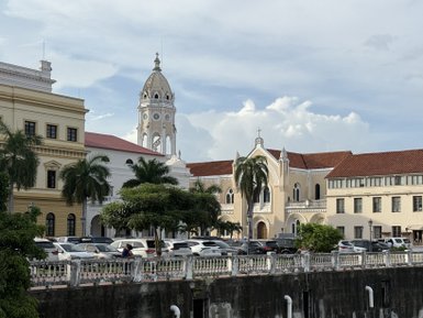 Eine malerische Straßenszene zeigt die elegante Architektur von Panama City, mit hohen Palmen und historischen Gebäuden im Hintergrund.