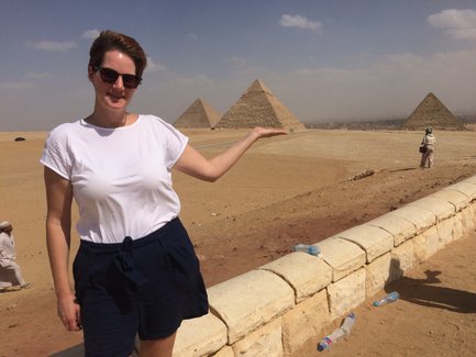 Frau posiert vor der Pyramide von Gizeh und hält sie für das Foto – Ägypten Reise mit Kindern