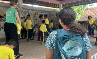 Ein Mädchen trägt einen FFR-Rucksack bei Yayasan Widya Guna – Bali Familienreise