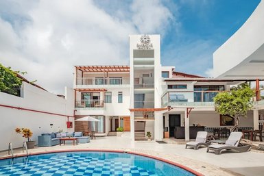 Ein modernes Boutique-Hotel mit einem einladenden Pool und stilvollen Liegen, umgeben von einer hellen, freundlichen Atmosphäre.