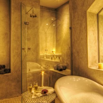 Ein elegantes Badezimmer mit einer freistehenden Badewanne, umgeben von warmem Licht und modernen Akzenten.