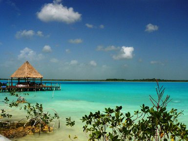Holzüberdachte Hütte am langen Steg über türkisfarbenem Wasser – Mexiko Reise mit Kindern