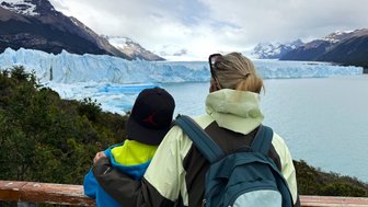 Eine Frau und ein Kind stehen am Geländer und betrachten den beeindruckenden Perito-Moreno-Gletscher in Patagonien.