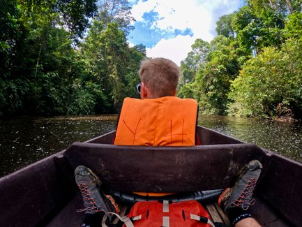 Kind genießt eine Bootsfahrt durch den dichten Regenwald des Taman Negara Nationalparks – Malaysia & Borneo Reise mit Kindern