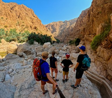Familie auf Wanderung im Wadi Shab – Oman mit Kindern